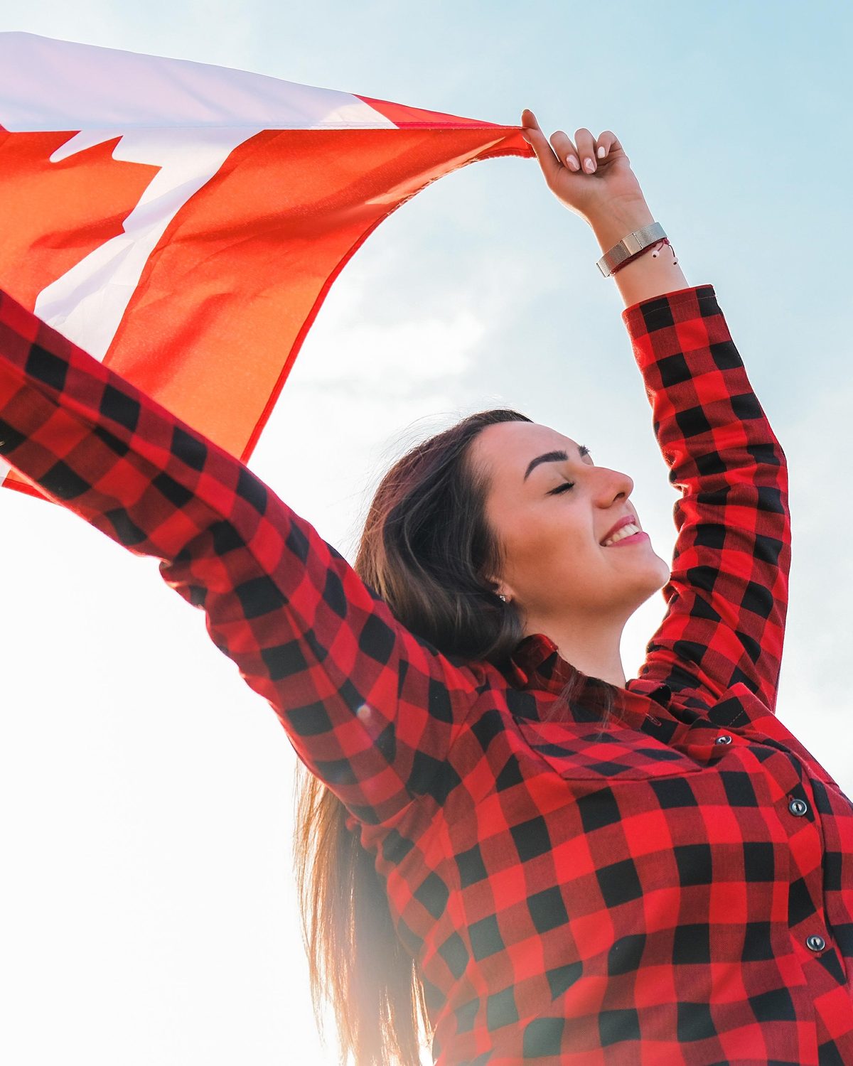 An immigration consultant holding a Canadian flag